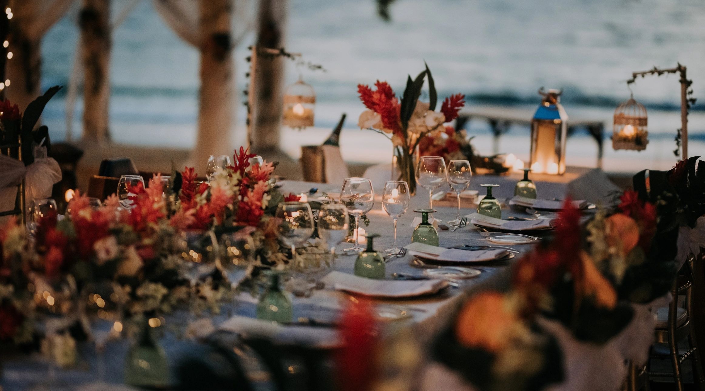 Elegantly decorated beachside dining table with floral centerpieces